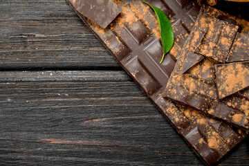 Slices of dark chocolate with cocoa powder.