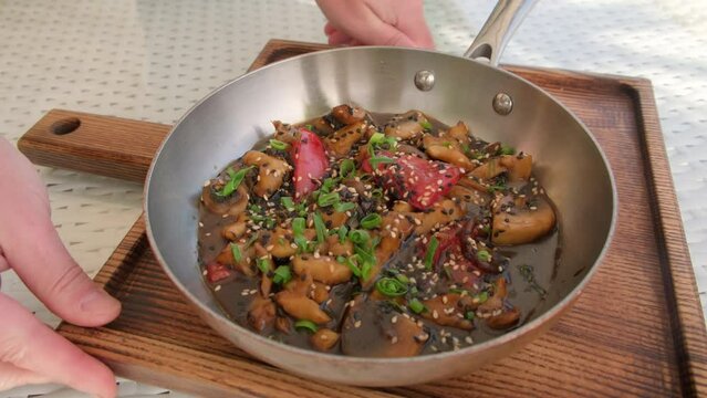 Serving hot frying pan with rapans in sea food restaurant. Fricassee dish of French cuisine.