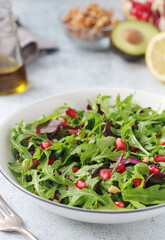 A plate with green rocket salad with pomegranate