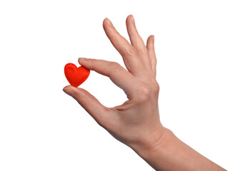 A woman's hand holds a small red heart with her fingers