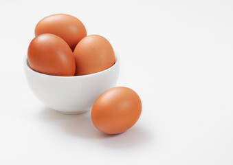 Organic raw chicken eggs in bowl plate on white background.