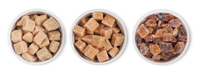 Obraz premium Bowl plates of natural brown unrefined and caramelized sugar cubes on white background.