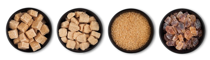 Black bowl plates of natural brown unrefined and caramelized sugar cubes on white background.