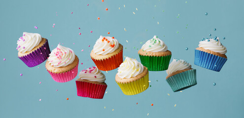 Banner with row of colorful cupcakes and falling sprinkles