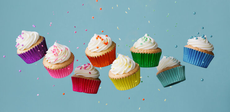 Banner with row of colorful cupcakes and falling sprinkles
