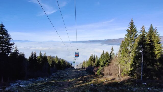 Cable car going up from the city of Sarajevo Capital of Bosnia and Herzegovina to Trebevic mountain. City below the clouds. Amazing travel destination. Tourism and vacations in the mountains. 