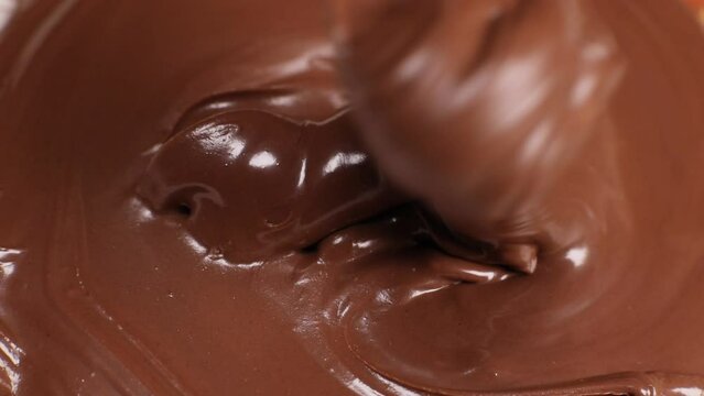 Spoon stirs delicious chocolate paste, butter close-up