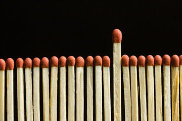 Set of matches arranged in a row where one stands out above all the others.