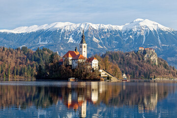 Sunrise winter scenery of magical Lake Bled in Slovenia. A winter tale for romantic experiences. Mountains with snow in the background. Church of the Mother of God on a little Island in the lake.