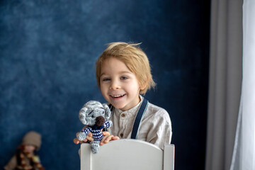 Naklejka premium Cute portirait of blond preschool child, boy, on blue background