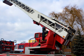 High retractable fire ladder with stall against blue sky, firefighter's rescue equipment. There is...