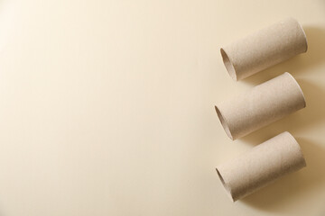 Empty toilet paper rolls on beige background flat lay. Space for text