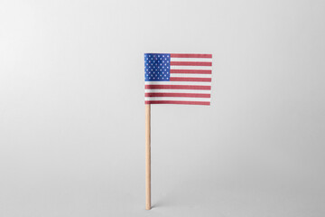 Fototapeta premium Small paper flag of USA on light background. Space for text