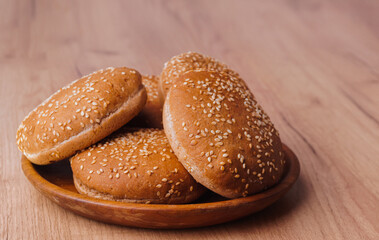 Fresh buns with sesame seeds on wooden table