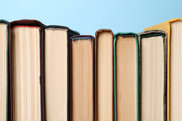 Many old books on light blue background, closeup