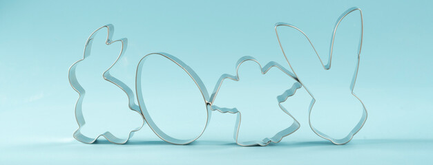 Easter bunny on blue background. Happy Easter Day concept. Minimal Easter concept. Space for text. Easter Cookie Cutter on baking background.