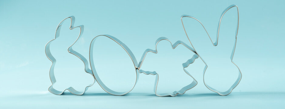 Easter bunny on blue background. Happy Easter Day concept. Minimal Easter concept. Space for text. Easter Cookie Cutter on baking background.