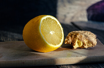 Lemon and ginger on a cutting board cooking medicinal tea.
