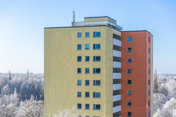 Buntes Wohnhochhaus mit Winterlandschaft im Hintergrund