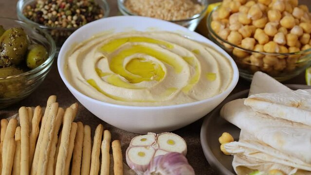 Chickpea hummus close up. Bowl of homemade natural organic hummus garnished with chickpeas, olive oil, spices. Hummus or fava, a hearty snack of legumes