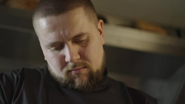Close-up of the face of a Caucasian chef preparing food in a restaurant. A man works in the kitchen, cutting vegetables for a salad. High quality 4k footage