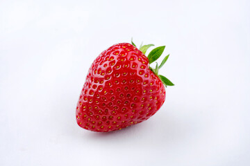 Reife rote Erdbeere aus biologischem Anbau angeboten als close-up auf einem weißem Board mit Textfreiraum 