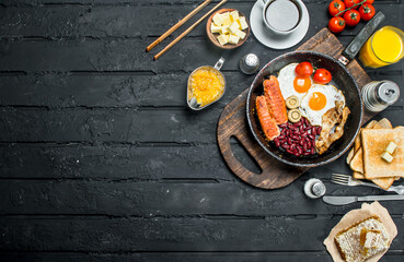 Traditional English Breakfast with fried eggs, sausages and aromatic coffee.