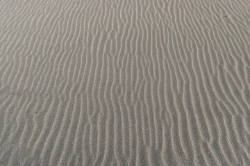 Textura de arena fina de playa con surcos en un atardecer