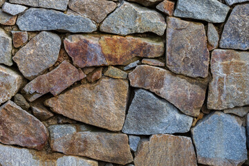 A wall built of large pieces of stone. A stone wall like a mosaic.