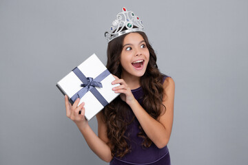 Child with gift present box on isolated background. Presents for birthday, Valentines day, New Year or Christmas. Excited face, cheerful emotions of teenager girl.