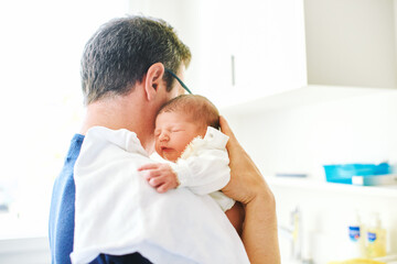 Father holding adorable newborn baby with sweet facial expression