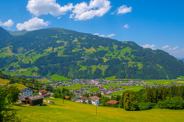 Fototapeta na wymiar Panoramic view of idyllic mountain scenery in the Alps with fresh green meadows in bloom on a beautiful sunny day in springtime