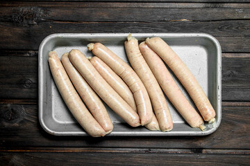 Raw sausage in a pan.