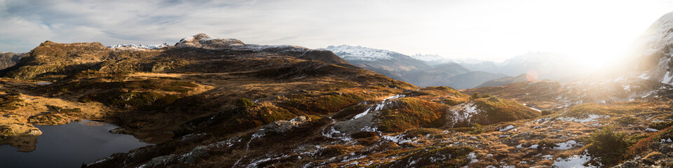 sunrise in the mountains covered by snow and with yellow grass