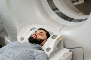 CT scan of brains of man in medical clinic. Man is doing computed tomography x-ray examination of...