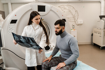 CT scan radiologist showing x-ray of abdomen to man patient in computed scanning room. CT Doctor...