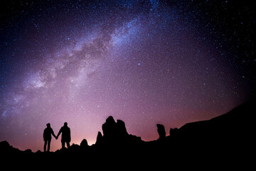 Loving couple in front of the milky way looking at the stars. Metaphor for astrology zodiac love...