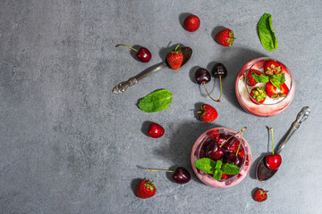 Delicious Italian dessert panna cotta with sweet cherry sauce, fresh strawberries and mint leaves