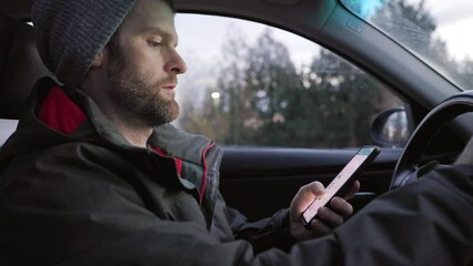 A middle aged caucasian man distracted driving while using a mobile device stops his vehicle suddenly to avoid an accident. 4K 24FPS