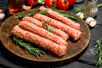 Raw sausages with herbs and tomatoes.