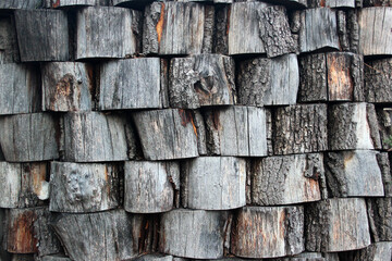 Stack of wooden stumps, wall of pine trunks as a background