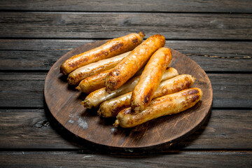 Grill beef sausages on a round Board.