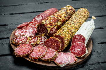 Different types of salami on wooden Board.