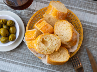 Bread sliced and served on table with green olives