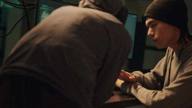 Team of hackers committing cybercrime or illegal activities on online network, trying to break into server. Dangerous people stealing information from government system, hacking at night.