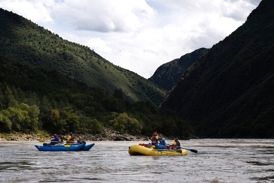 Rubber rafts row downstream during a whitewater rafting trip to Western China.