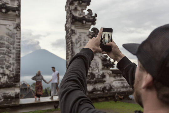Tourist photographing couple at Pura Lempuyang temple, Bali, Indonesia