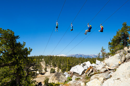 Family riding zip line, South Lake Tahoe, California, USA