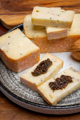 Italian cheese collection, yellow taleggio cheese with black truffles mushrooms