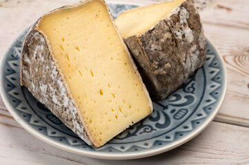 Pieces of cheese tomme de montagne or tomme de savoie made from cow milk in French Alps